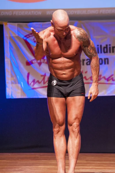 Male bodybuilder shows his best at championship on stage — Stock Photo, Image