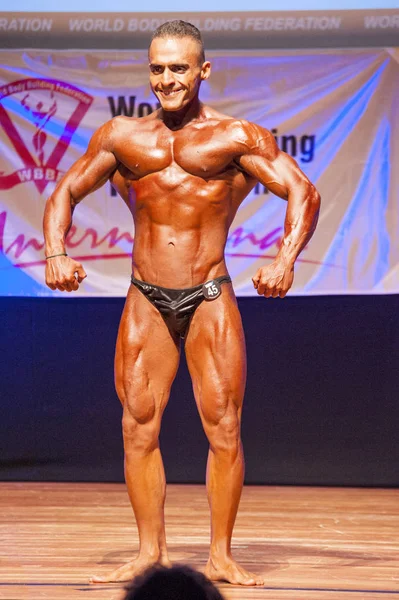 Männlicher Bodybuilder lässt seine Muskeln spielen, um seinen Körperbau zu zeigen — Stockfoto