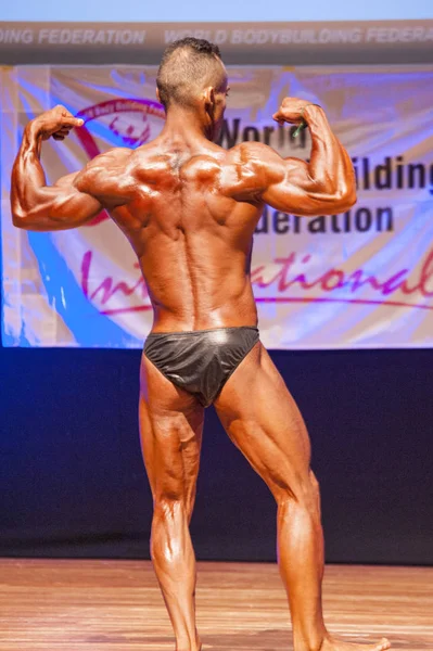 Männlicher Bodybuilder lässt seine Muskeln spielen, um seinen Körperbau zu zeigen — Stockfoto