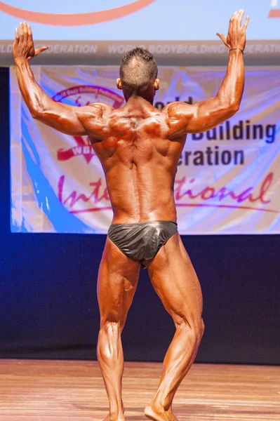 Männlicher Bodybuilder lässt seine Muskeln spielen, um seinen Körperbau zu zeigen — Stockfoto