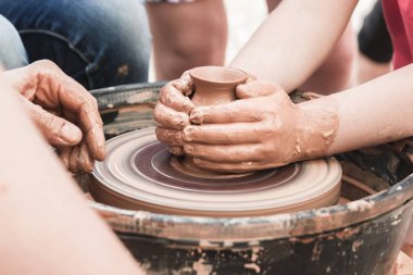 Çocuklarla çömlekçi tekerleğinde seramik üretim sürecine yakından bak. Çocuk konsepti ile Kil el sanatları.