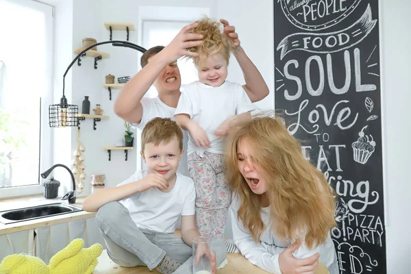 Happy family at home spending time together and playing. Crazy family heaving fun in dright kitchen room.