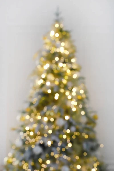 Blur celebración de la luz en el árbol de Navidad con fondo blanco de la pared. Desenfoque fondo de vacaciones . —  Fotos de Stock
