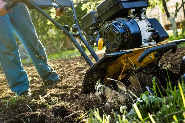 Hierba y pepitas de tierra arada durante el trabajo de jardín de cultivadores de motor — Foto de Stock