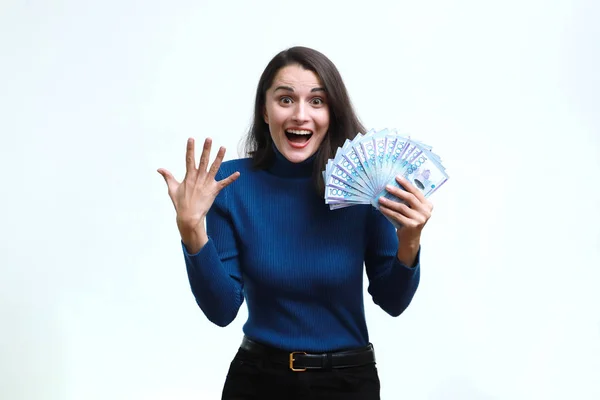 Šťastná žena se raduje z tenge peněz na homogenním pozadí. — Stock fotografie