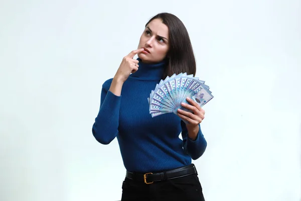 Mulher bonita com dinheiro tenge nas mãos em um fundo branco . — Fotografia de Stock