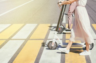 Cross Road üzerinde scooter ile yürüyüş kadın bacaklar ve erkek bacaklar