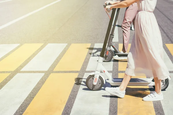Cross Road üzerinde scooter ile yürüyüş kadın bacaklar ve erkek bacaklar