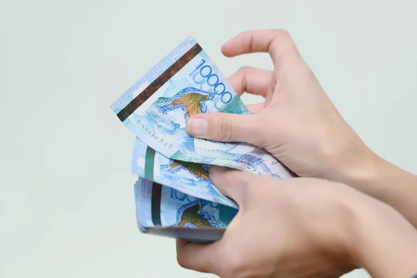 La mano femenina sostiene la moneda nacional de Kazajstán tenge. —  Fotos de Stock