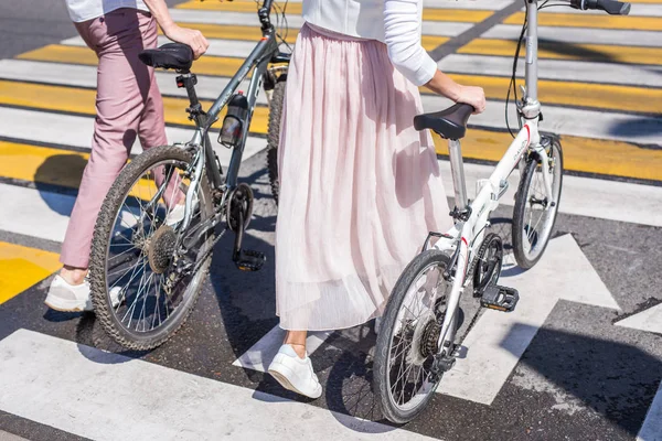 Piernas de mujer y piernas de hombre caminando con bicicletas en cruce de caminos —  Fotos de Stock