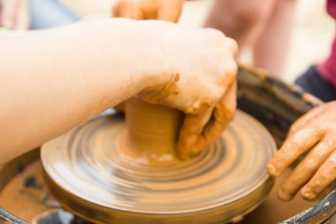 Çocuklarla çömlekçi tekerleğinde seramik üretim sürecine yakından bak. Çocuk konsepti ile Kil el sanatları.