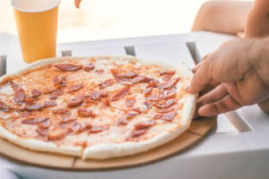 Sosis ve peynirile yakın çekim bütün pizza. Plaj yemekleri.