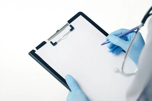 Doctor holding medical clipboard with empty blank sheet of paper and stethoscope. Concept of healthcare and medicine. Empty clipboard template and copy space