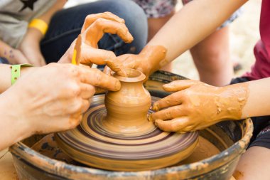 Çocuklarla çömlekçi tekerleğinde seramik üretim sürecine yakından bak. Çocuk konsepti ile Kil el sanatları.