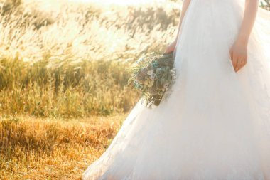 Tourquoise renk detayları ile rustik düğün buketi tutan parmaklarında tırnak sanat ve yüzük ile gelin kolu na yakın görünümü.