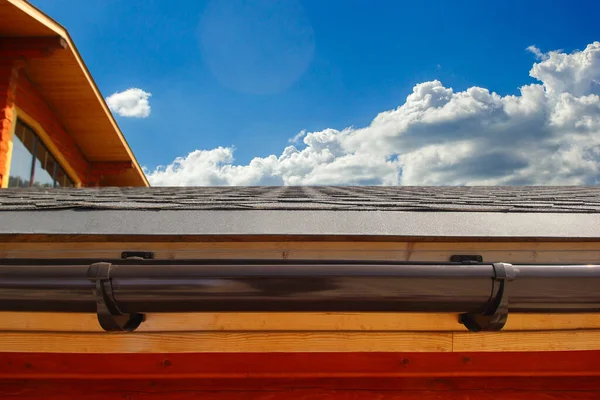 Water drain system on the roof of the house. Brown plastic drain.