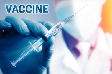 Mavi lateks eldivenli ve şeffaf şırıngalı tıbbi gazlı bez maskeli doktorun elini kapat. Sağlık ve aşı kavramı