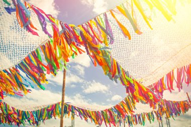 Mavi güneşli gökyüzü arkaplanındaki şenlikli olay için renkli kurdele dekorasyon çadırı