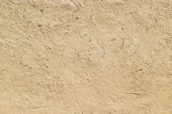 Adobe - clay and straw material weathered wall of rural old country house close-up as clay background