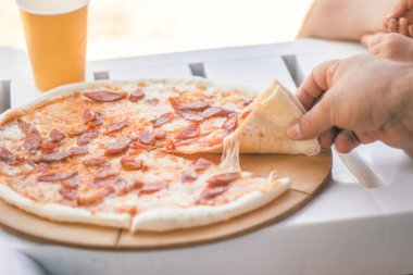 Sosis ve peynirile yakın çekim bütün pizza. Plaj yemekleri.
