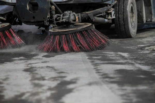 Street cleaner vehicle on the road collecting garbage and junk with brush rotation and vacuum hoover