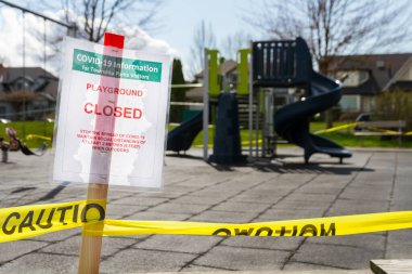 Küçük bir oyun parkı önündeki COVID-19 önleme tedbirleri nedeniyle oyun parkı kapalı işareti.