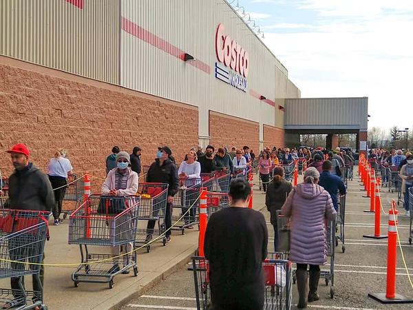 LANGLEY, Kanada - 14 Nisan 2020. Müşteriler, 14 Nisan 2020 'deki Coronavirus salgını sırasında dükkana girmek için Costco girişinde sırada bekliyorlar..