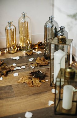 şık ve pahalı bir düğün dekoru, cam vazolarda çiçekler, altın, ışıklar, mumlar. 