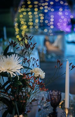 şık ve pahalı düğün dekoru, altın, mum, ışık, çiçek, şık bardaklar ve tabaklar kullanarak masa düzenleme