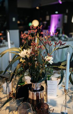 şık ve pahalı düğün dekoru, altın, mum, ışık, çiçek, şık bardaklar ve tabaklar kullanarak masa düzenleme