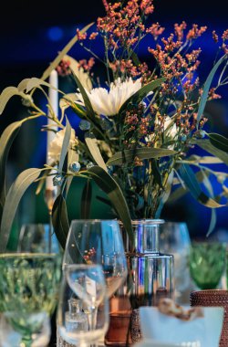 şık ve pahalı düğün dekoru, altın, mum, ışık, çiçek, şık bardaklar ve tabaklar kullanarak masa düzenleme