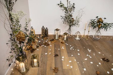 şık ve pahalı bir düğün dekoru, cam vazolarda çiçekler, altın, ışıklar, mumlar. 