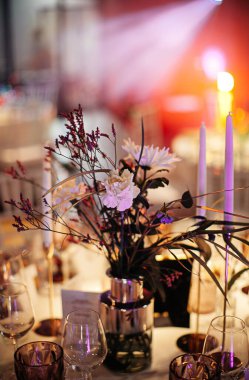 şık ve pahalı düğün dekoru, altın, mum, ışık, çiçek, şık bardaklar ve tabaklar kullanarak masa düzenleme