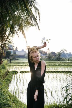 Sarışın blogcu kız Endonezya 'ya seyahat ederken pirinç tarlasında yoga ve meditasyon yapıyor.