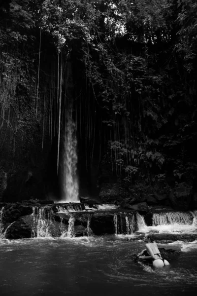 Bali adasında Endonezya 'ya seyahat ederken mayo giymiş sarışın bir blog yazarı vahşi bir şelalede cinsel olarak poz veriyor.