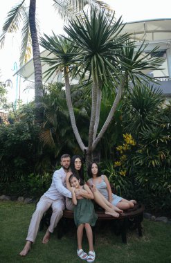 Mutlu Asyalı aile kucaklaşıp eğleniyor ama Endonezya 'nın Bali adasında tatil yapıyor.