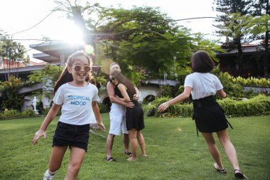 Mutlu Asyalı aile kucaklaşıp eğleniyor ama Endonezya 'nın Bali adasında tatil yapıyor.