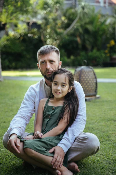 happy asian family dad and daughter hugging and having fun on a walk on vacation in Bali island in Indonesia