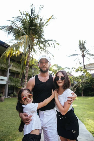 인도네시아 발리의 이국적 섬에서 휴가를 보내고 아버지와 여동생들 미소짓고 껴안고 — 스톡 사진