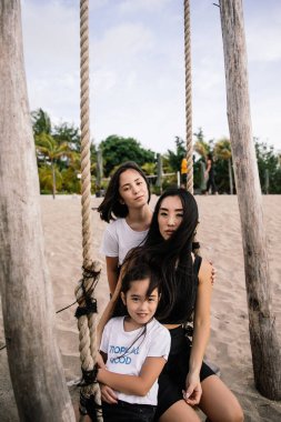 Mutlu aile Endonezya 'nın Bali sahilinde tatilde eğleniyor ve sarılıyor.