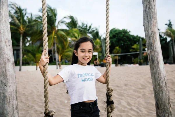 印尼巴厘岛 一个可爱的亚洲小女孩骑在秋千上 在海滩上玩得很开心 — 图库照片