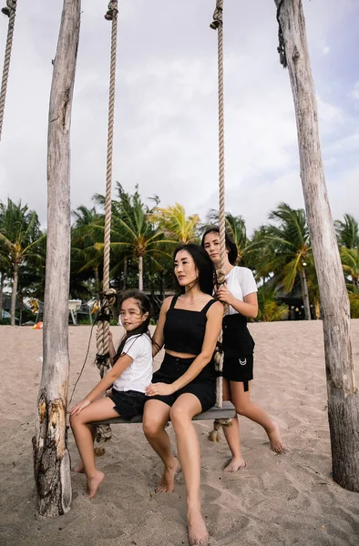 快乐的家庭在印尼巴厘岛的海滩上度假和拥抱 — 图库照片