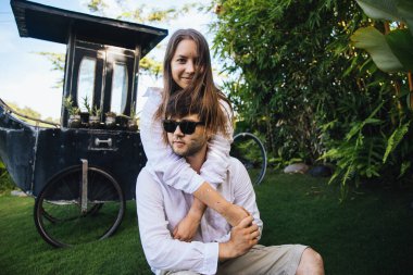 Birbirine aşık çiftler, Endonezya 'nın Bali adasında, palmiye ağaçlarının yanında romantik bir yürüyüşe çıkıp eğleniyorlar.