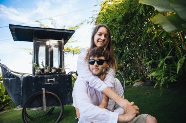 Birbirine aşık çiftler, Endonezya 'nın Bali adasında, palmiye ağaçlarının yanında romantik bir yürüyüşe çıkıp eğleniyorlar.