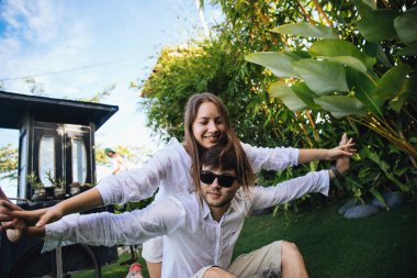 Birbirine aşık çiftler, Endonezya 'nın Bali adasında, palmiye ağaçlarının yanında romantik bir yürüyüşe çıkıp eğleniyorlar.