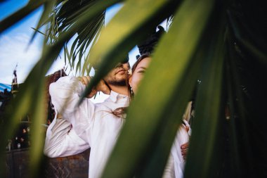 Birbirine aşık çiftler, Endonezya 'nın Bali adasında, palmiye ağaçlarının yanında romantik bir yürüyüşe çıkıp eğleniyorlar.