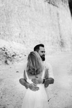 Birbirine aşık çiftler - gelin ve damat düğün günlerinde okyanus kenarında, Endonezya 'nın egzotik Asya adası Bali' de sarılıp öpüşürler. 