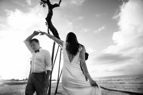 在印度尼西亚巴厘岛的一个奇异的亚洲岛屿上 一对恋人 新郎新娘 在婚礼当天 拥抱并亲吻海滩上奇异的风景 — 图库照片