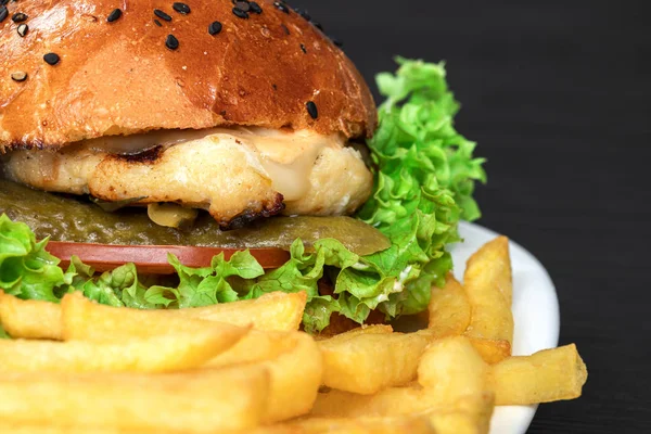 Savoureux hamburger appétissant sur un terrel blanc avec des frites sur fond gris — Photo
