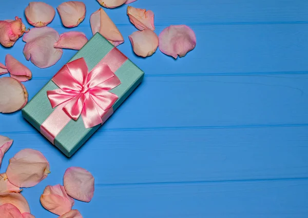 Caja de regalo azul apretado por una cinta rosa sobre un fondo azul Fotos De Stock Sin Royalties Gratis